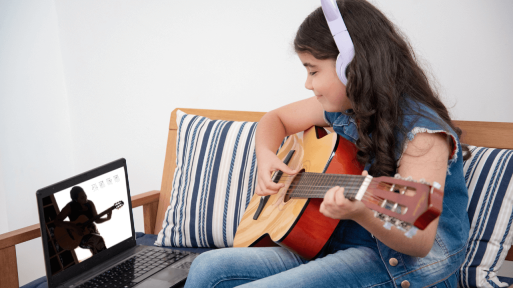 Kid learning how to play guitar through youtube videos